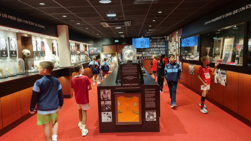Équipe U11 du FCAV devant la vitrine des trophées au musée du Stade Rennais.